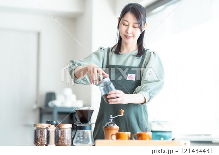 カフェでコーヒー豆をドリッパー入れるミドルの女性 121434431