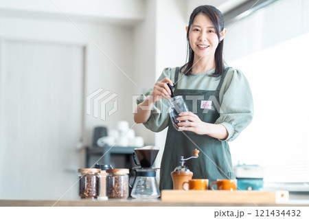 カフェでコーヒー豆をドリッパー入れるミドルの女性 121434432