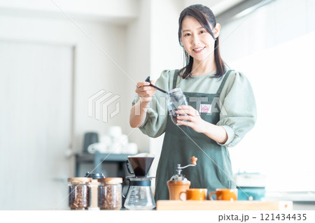 カフェでコーヒー豆をドリッパー入れるミドルの女性 121434435