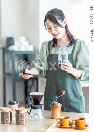 カフェでコーヒー豆をドリッパー入れるミドルの女性 121434436