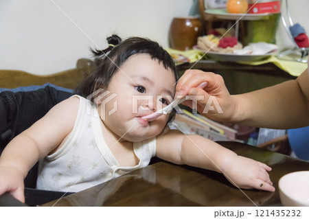 【離乳食を食べる髪を結んだ赤ちゃん】 【離乳食を食べる髪を結んだ赤ちゃん】 121435232