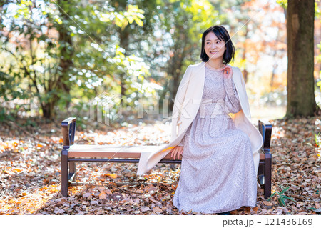 自然豊かな公園のベンチに座るミドルの女性 自然豊かな公園のベンチに座るミドルの女性 121436169