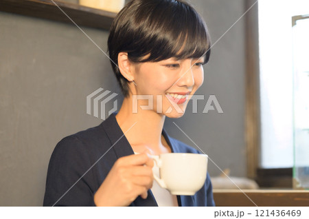 カフェでコーヒーを飲みながらパソコンも見る女性 カフェでコーヒーを飲みながらパソコンも見る女性 121436469