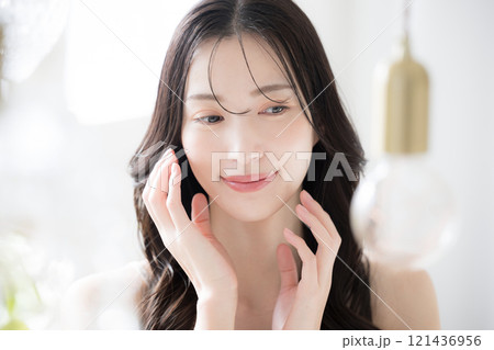 美しい若い女性の素肌感が美しい手が頬に触れるビューティーイメージクローズアップ 121436956