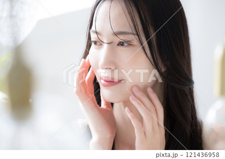 美しい若い女性の素肌感が美しい手が頬に触れるビューティーイメージクローズアップ 美しい若い女性の素肌感が美しい手が頬に触れるビューティーイメージクローズアップ 121436958