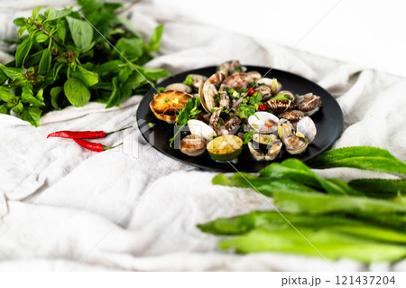 Fresh seafood platter features garlic clams and mussels alongside vibrant herbs and chili. Fresh seafood platter features garlic clams and mussels alongside vibrant herbs and chili. 121437204