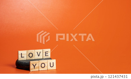 Text of Love You in wooden blocks on a colored background Text of Love You in wooden blocks on a colored background 121437431