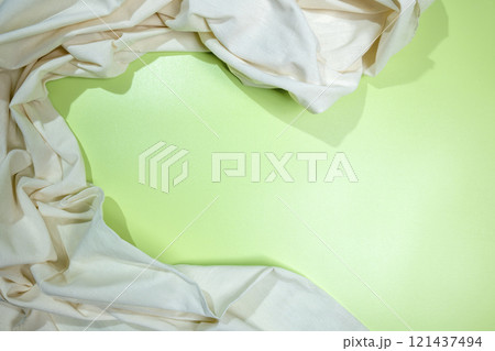 Top view of crumpled white fabric on a colored background 121437494