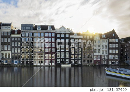 Panoramic view of facades of colorful Amsterdam houses reflecting in the river canal with sunlight background 121437499