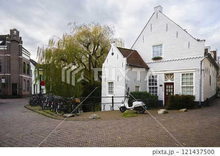 City street with a view of the facades of Amersfoort houses with a motorcycle and bicycles in Amersfoort 121437500
