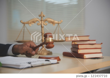 Judge gavel and miniature car symbolize auction or court case against driver who has accident and receiving vehicle insurance payment be on table in front of hands of lawyers. Selective focus 121437710