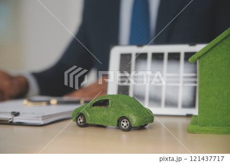 Judge gavel and miniature car symbolize auction or court case against driver who has accident and receiving vehicle insurance payment be on table in front of hands of lawyers. Selective focus 121437717