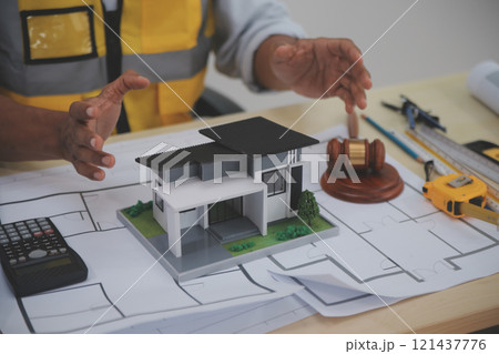 Judge gavel on building blueprint plans with a yellow safety helmet in the background. law that deals with matters relating to building construction, engineering. Construction law concept. Judge gavel on building blueprint plans with a yellow safety helmet in the background. law that deals with matters relating to building construction, engineering. Construction law concept. 121437776