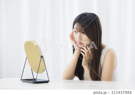 鏡を見て肌を気にする若い女性 鏡を見て肌を気にする若い女性 121437988