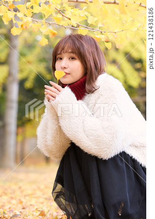 秋の公演で散歩をするファージャケットを着た女性 121438186