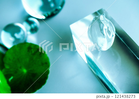 Aloe serum and centella drops rest on a clear surface among calming spa elements. Aloe serum and centella drops rest on a clear surface among calming spa elements. 121438273