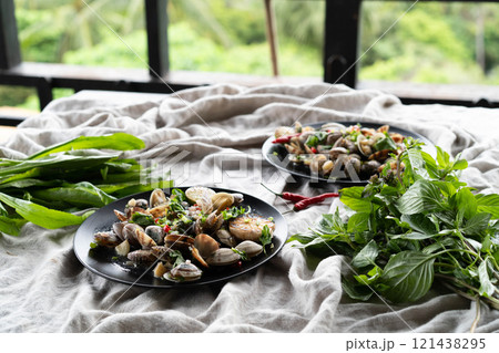 Tables adorned with clams and mussels, garlic, herbs, and lush greenery. 121438295