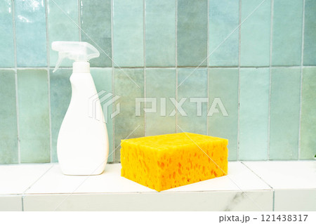 Cleaning supplies including a spray bottle and sponge ready for tile repair work. 121438317