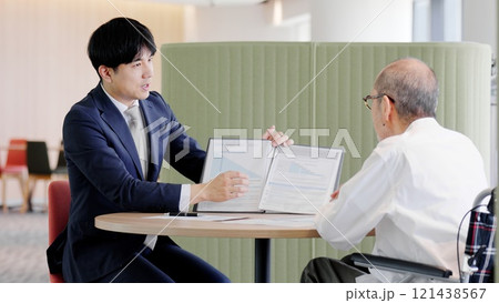 高齢者に営業をするビジネスマン	 121438567