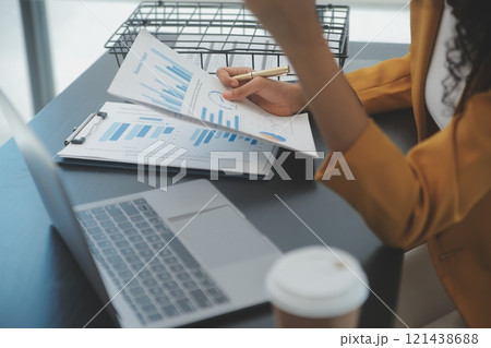Close up Business woman using calculator and laptop for do math finance on wooden desk, tax, accounting, statistics and analytical research concept 121438688