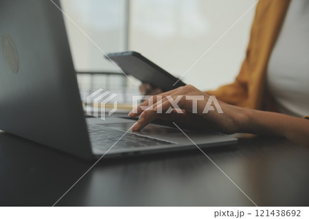 Close up Business woman using calculator and laptop for do math finance on wooden desk, tax, accounting, statistics and analytical research concept Close up Business woman using calculator and laptop for do math finance on wooden desk, tax, accounting, statistics and analytical research concept 121438692
