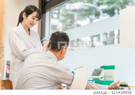 病院・クリニックで人間ドック・健康診断する男性と医師（血圧） 121439956