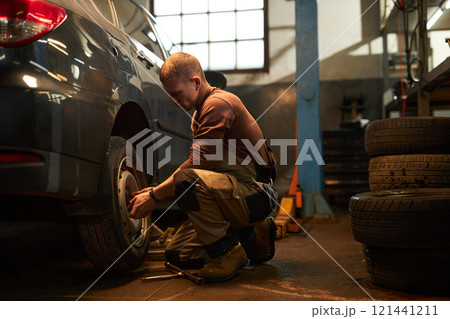 Mechanic Examining The Wheels Of Car Mechanic Examining The Wheels Of Car 121441211