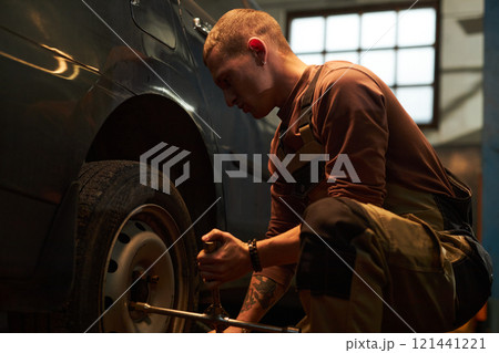 Technician Repairing Wheels In Car Service Technician Repairing Wheels In Car Service 121441221