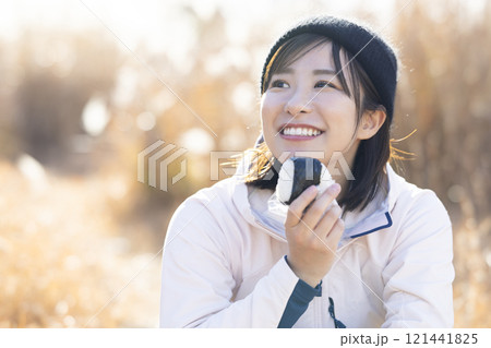 おにぎりを食べる女性 121441825