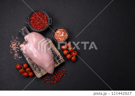 Pieces of raw chicken or turkey fillet with salt, spices and herbs 121442027