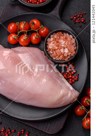 Pieces of raw chicken or turkey fillet with salt, spices and herbs 121442045