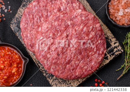Fresh raw ground beef burger patty with salt and spices 121442338