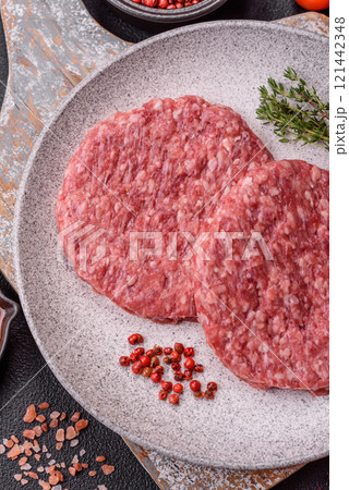 Fresh raw ground beef burger patty with salt and spices Fresh raw ground beef burger patty with salt and spices 121442348