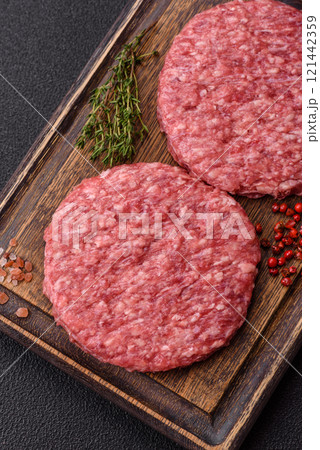 Fresh raw ground beef burger patty with salt and spices 121442359