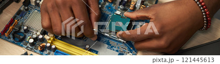 Man Repairing Computer Motherboard In Workshop 121445613