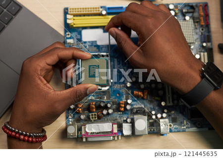 Repairman Setting Chip In Motherboard 121445635