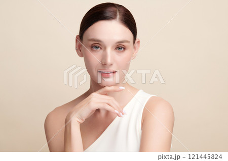 Beautiful young woman with clean fresh skin on beige background, Face care, Facial treatment, Cosmetology, beauty and spa, women portrait. 121445824