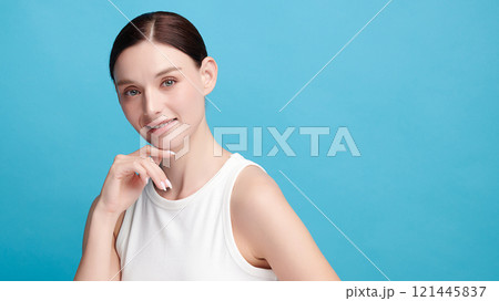 Beautiful young woman with clean fresh skin on blue background, Face care, Facial treatment, Cosmetology, beauty and spa, women portrait. Beautiful young woman with clean fresh skin on blue background, Face care, Facial treatment, Cosmetology, beauty and spa, women portrait. 121445837