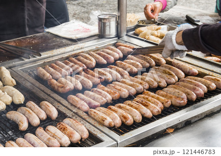 Close-up of the vendors grilling Taiwanese sausage and sticky rice (glutinous rice) sausage in the night market in Taiwan. This is one of the street snacks popular among tourists in Taiwan. 121446783