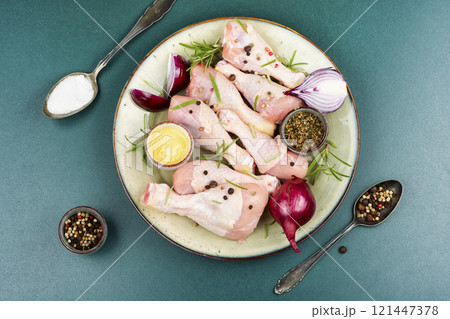 Raw chicken leg pieces with spices. 121447378
