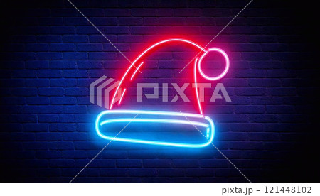 A colorful neon Christmas hat lights up the dark wall, creating a festive ambiance with its glow 121448102