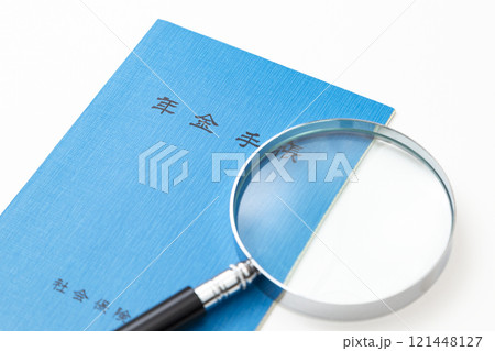 白背景に年金手帳と虫眼鏡 白背景に年金手帳と虫眼鏡 121448127