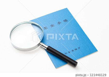白背景に年金手帳と虫眼鏡 白背景に年金手帳と虫眼鏡 121448129