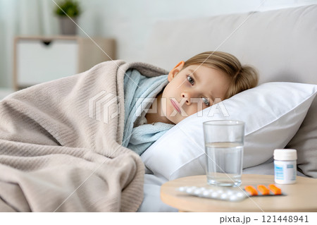 sick woman lying on bed and taking pills 121448941