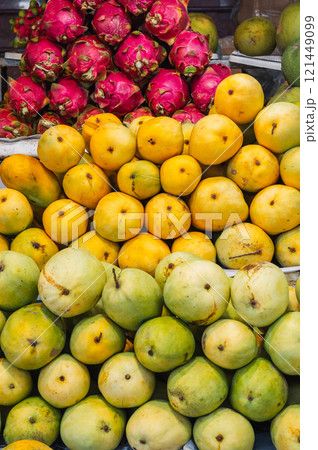 A colorful fruit display case made of mangoes and dragon fruit on display at the local market 121449099