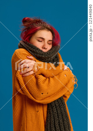 Woman shivering, wrapped in scarf, suggesting chills from viral flu or cold. Focus on maintaining body warmth and proper illness care. Woman shivering, wrapped in scarf, suggesting chills from viral flu or cold. Focus on maintaining body warmth and proper illness care. 121449840