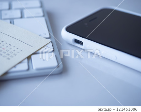 テーブルに置かれたカレンダーとキーボードとスマホ テーブルに置かれたカレンダーとキーボードとスマホ 121451006