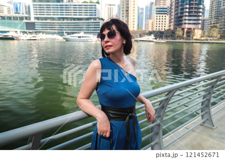 Vacation of a middle-aged woman, a walk along the embankment of a large European city Vacation of a middle-aged woman, a walk along the embankment of a large European city 121452671