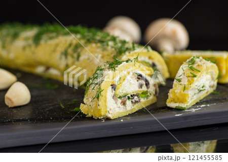 baked potato roll with cottage cheese filling with garlic and mushrooms, isolated on black background baked potato roll with cottage cheese filling with garlic and mushrooms, isolated on black background 121455585