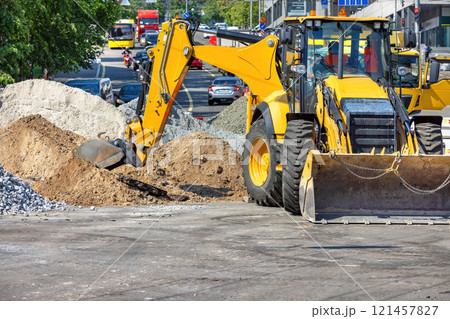 Heavy machinery at work on a busy city street during midday construction. Copy space. Heavy machinery at work on a busy city street during midday construction. Copy space. 121457827